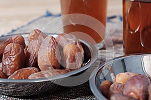 Bowl of dates fruit with glass of tea