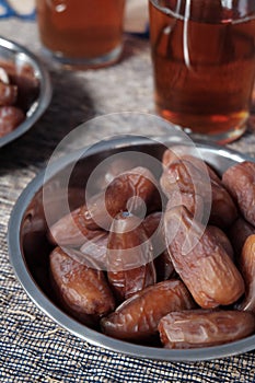 Bowl of dates fruit and glass of tea