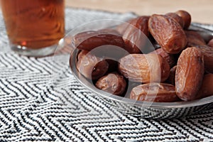 Bowl of dates fruit and glass of tea