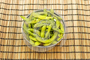 Glass bowl with metal edge filled with edamame with salt flakes photo