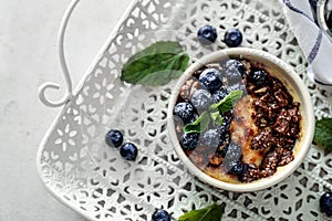 Bowl with delicious blueberry pudding on tray