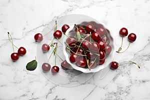 Bowl of delicious cherries on marble background