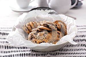 Bowl with delicious cookies with chocolate chips on table