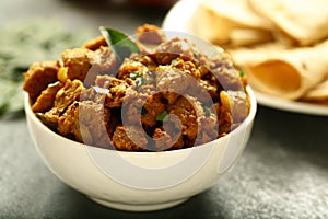 Bowl of delicious mutton curry and paratha.