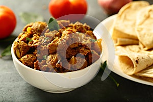 Bowl of delicious mutton curry and paratha.