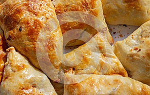 Bowl with delicious samosas on light background