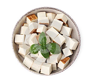 Bowl with delicious smoked tofu and basil on white background