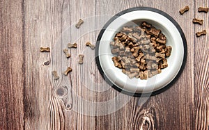 A bowl of dog food on a wooden floor