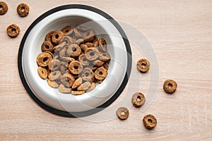 A bowl of dog food on a wooden floor