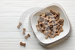 A bowl of dog food on a wooden floor