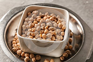 Bowl with dry chickpeas on table