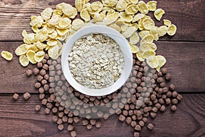 Bowl of dry oats with corn flakes on wooden background