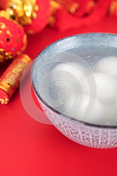 A bowl of dumplings or Yuanxiao on a festive red background