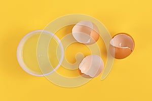 Bowl with egg white next to broken eggshells photo