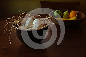 Bowl of eggs and bowl of fruit on table