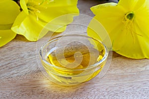 A bowl of evening primrose oil with blooming evening primrose