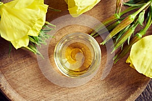 A bowl of evening primrose oil with fresh blooming evening primrose