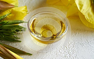 A bowl of evening primrose oil with fresh evening primrose flowers