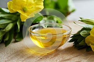 A bowl of evening primrose oil with fresh evening primrose flowers