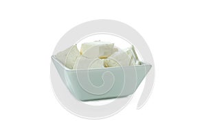 Bowl with feta cheese pieces isolated on white background