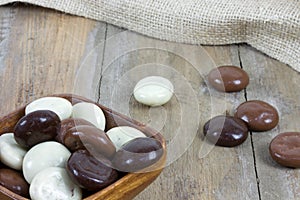 Bowl filled with chocolate kruidnoten on wooden surface