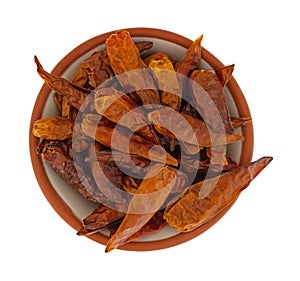 Bowl filled with dried Vietnamese chili peppers on a white background top view