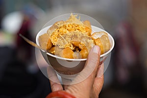 Bowl of finger - shaped soufle porridge on woman hand. Vietnamese food