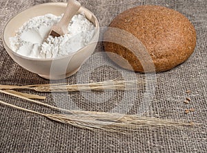 Bowl with flour and ears of wheat