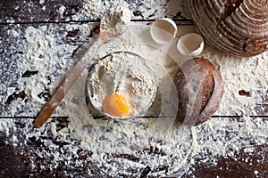 Bowl of flour with egg and bread