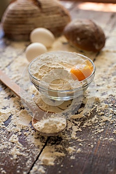 Bowl of flour with eggs and bread