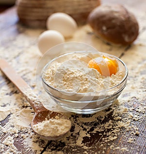 Bowl of flour with eggs and bread