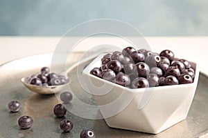 Bowl with fresh acai berries on tray