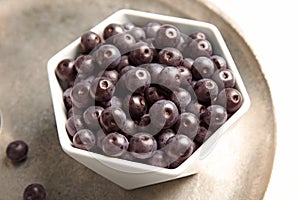 Bowl with fresh acai berries on tray