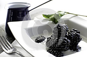 Bowl of fresh blackberries and milk.