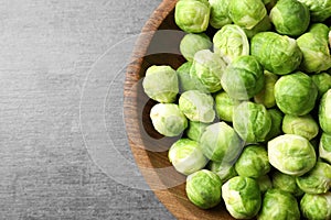 Bowl of fresh Brussels sprouts on grey background