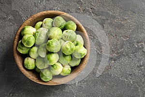 Bowl of fresh Brussels sprouts on grey background