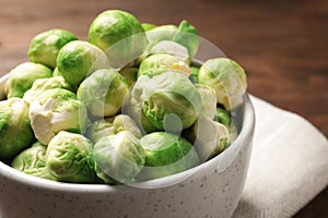 Bowl of fresh Brussels sprouts on table, closeup.