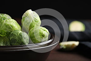 Bowl with fresh Brussels sprouts on table, closeup