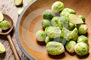 Bowl with fresh Brussels sprouts on wooden table