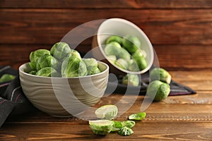 Bowl with fresh brussels sprouts on wooden table