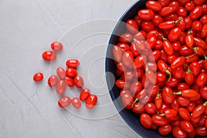 Bowl with fresh goji berries on grey background