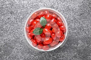 Bowl with fresh goji berries on grey background