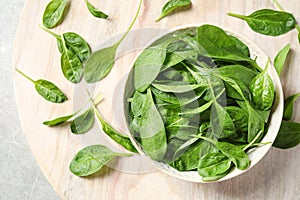 Bowl of fresh green healthy spinach on table