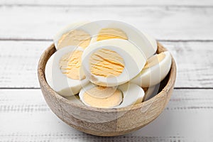 Bowl of fresh hard boiled eggs on white wooden table, closeup