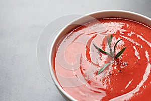 Bowl with fresh homemade tomato soup and space for text on grey background