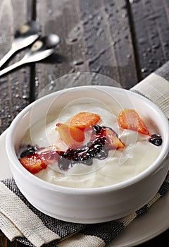 Bowl of fresh mixed berries and yogurt with farm fresh Papaya on a wooden table