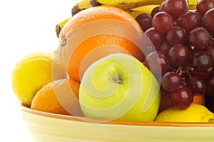 Bowl of fresh mixed fruit, backlit.