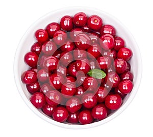 Bowl of fresh red cherries and green leaf isolated on a white background top view