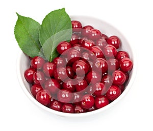 Bowl of fresh red cherries and green leaves isolated on a white background, top view