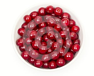 Bowl of fresh red cherries isolated on a white background, top view